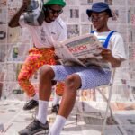 Two stylish men in Nigeria enjoying a sunny day with vintage style and flair.